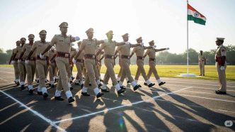 Police Constable Recruitment marching in a disciplined formation on a training ground with a senior officer and the Indian flag.